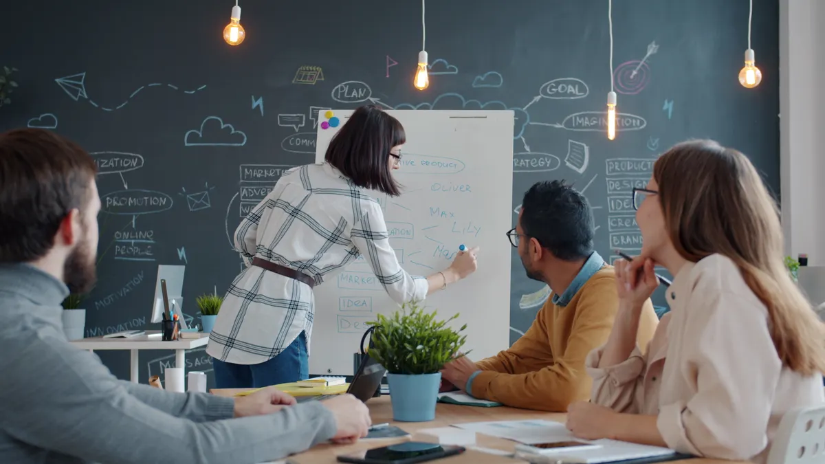 team brainstorming around a whiteboard in an office