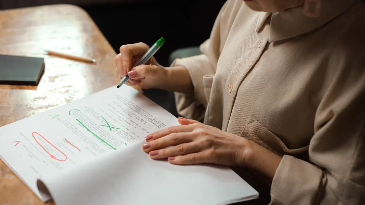 Person marking edits on a document with red and green pen marks