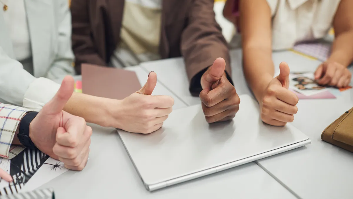 How to Build an Approval Policy for AI-Assisted Blog Publishing group giving thumbs up around a laptop