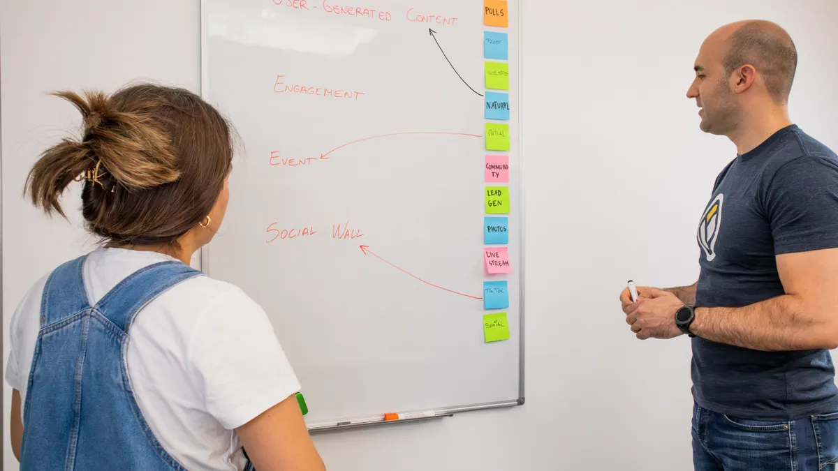 How to Map Roles and Responsibilities in AI Blog Production Two coworkers reviewing a task map on a whiteboard