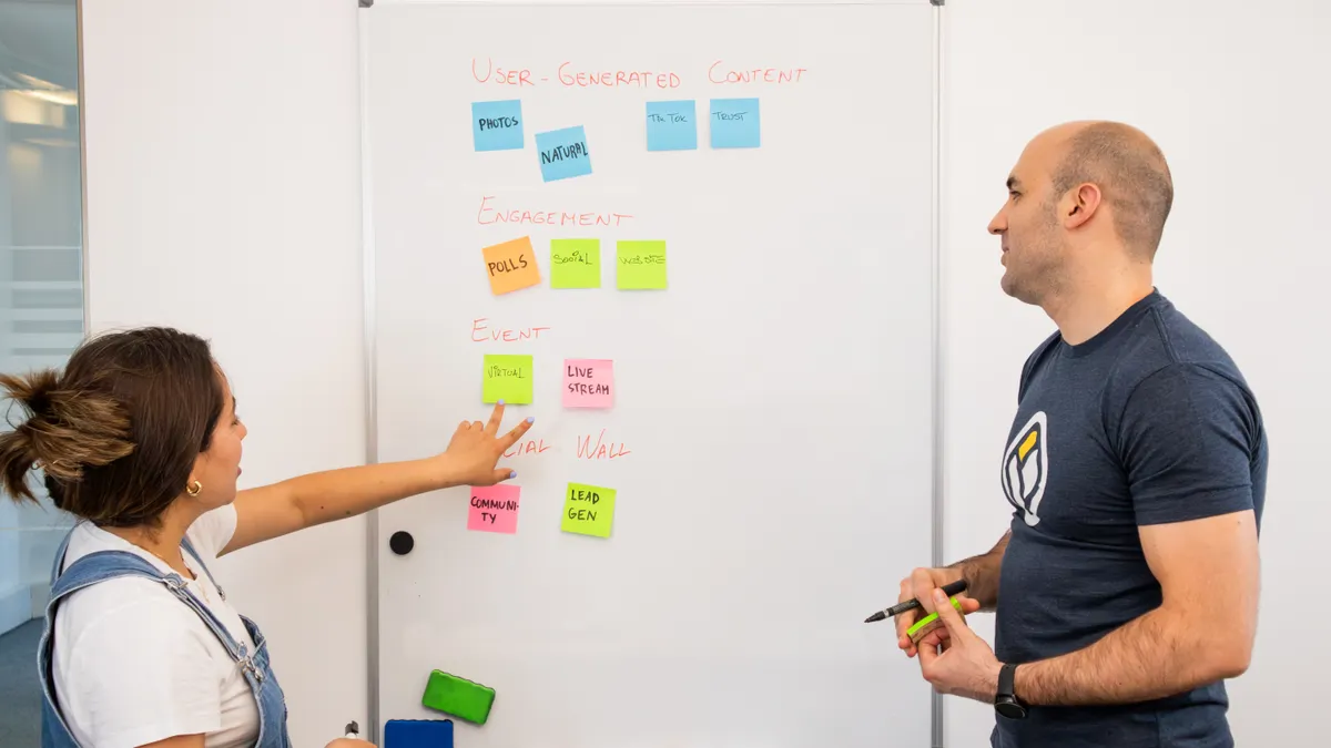 How to set up roles and handoffs in an AI blog workflow Two coworkers arranging sticky notes on a whiteboard