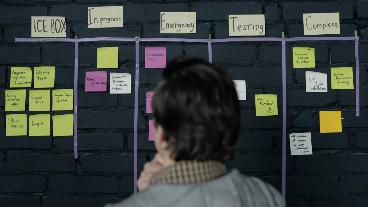 Person viewing a kanban board with sticky notes